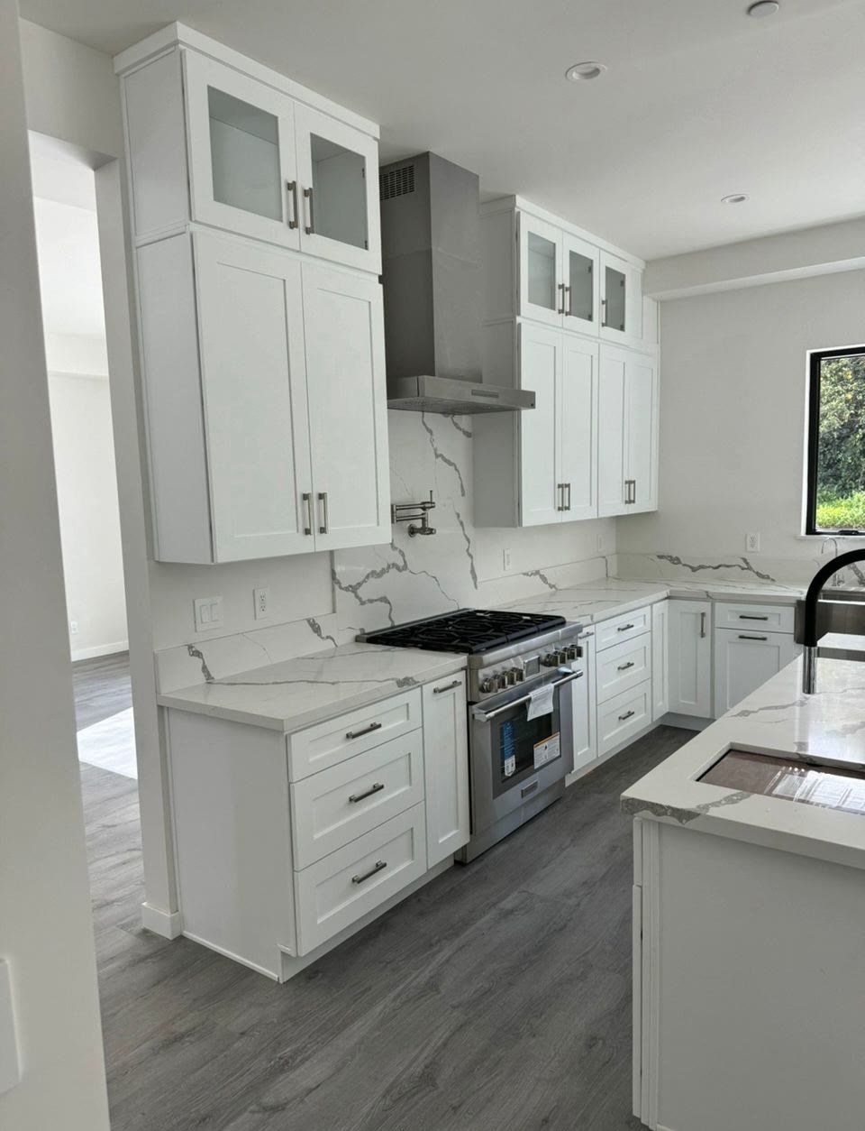 Completed white kitchen with marble backsplash