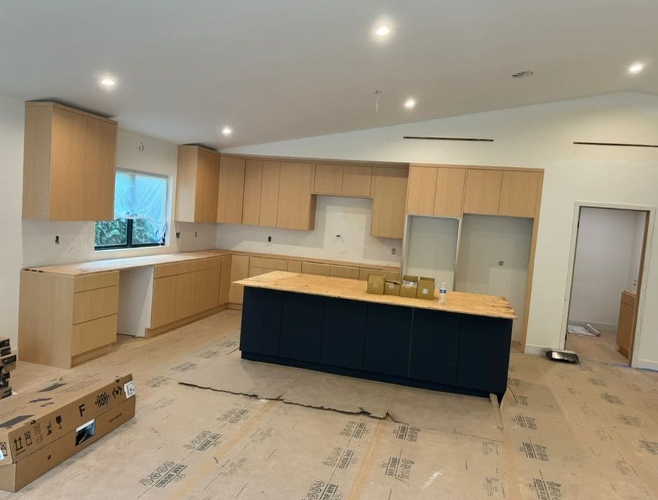 Light wood kitchen with navy island installation
