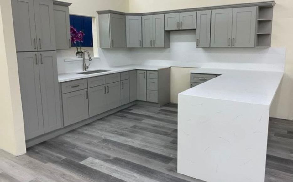 Completed gray kitchen with white waterfall peninsula
